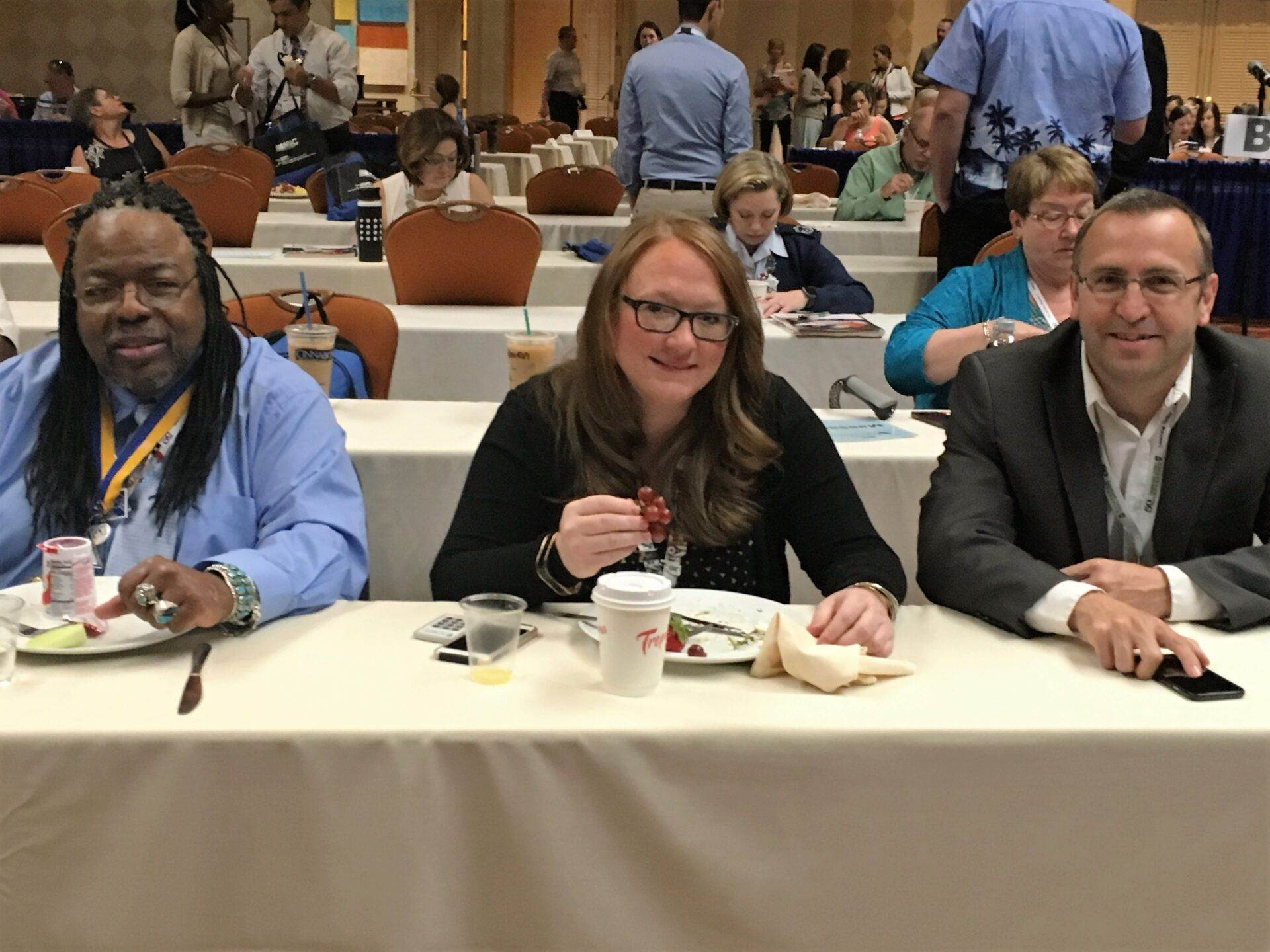 A group of people sitting at a table at a conference.