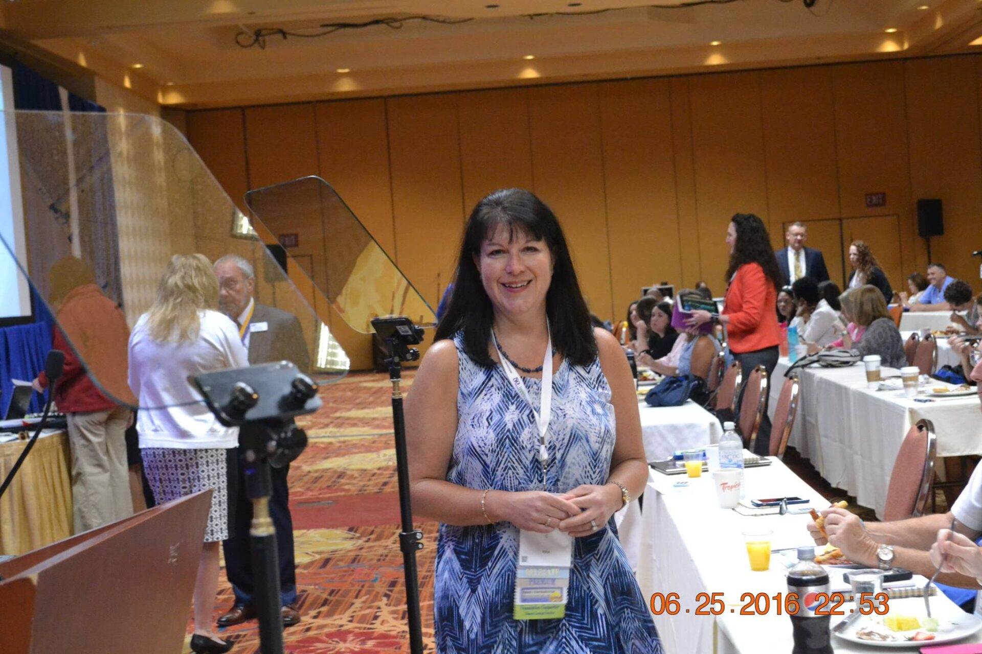 A woman standing in front of a conference table.